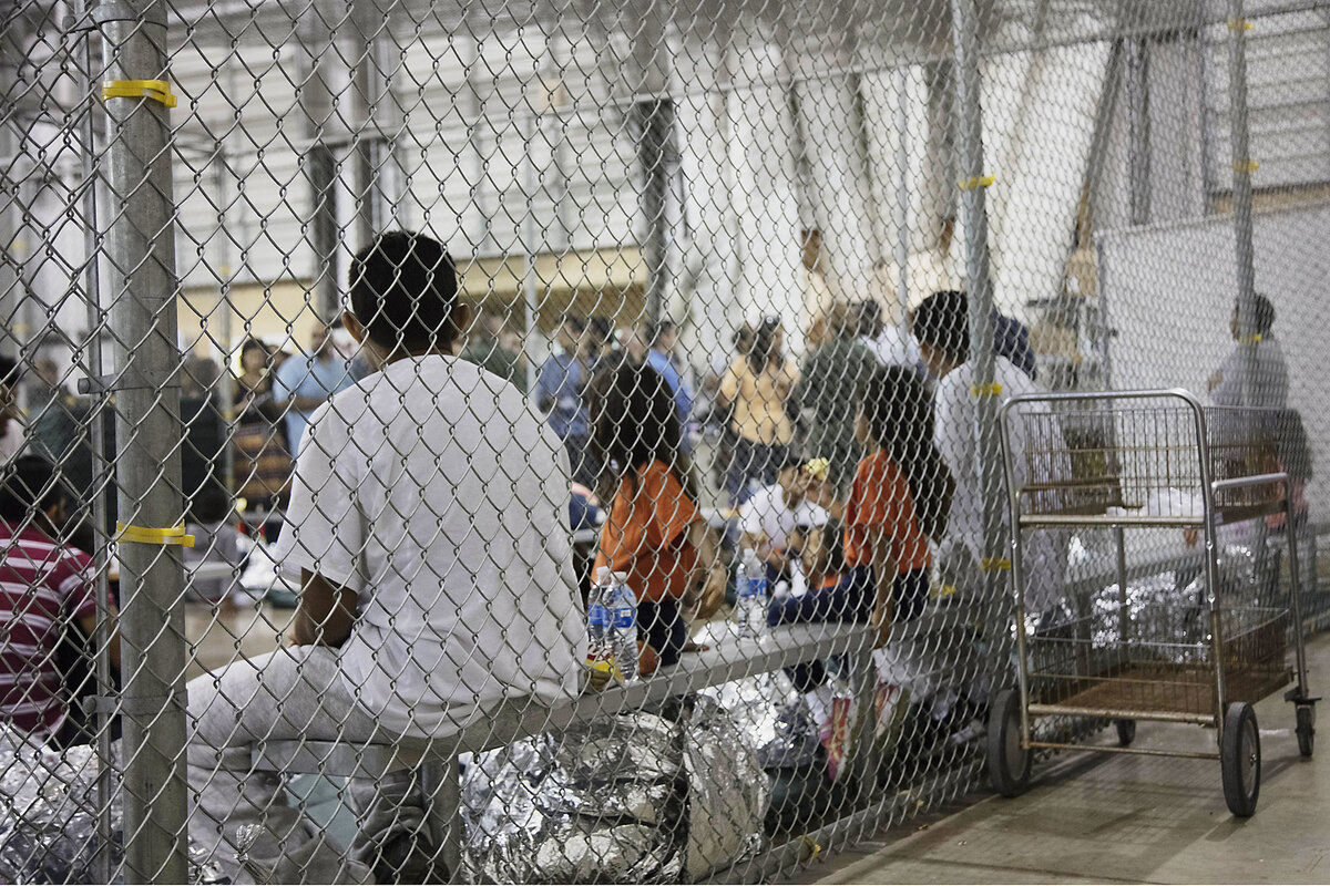 People who were taken into custody related to cases of illegal entry into the United States sit at a government facility in McAllen, Texas.