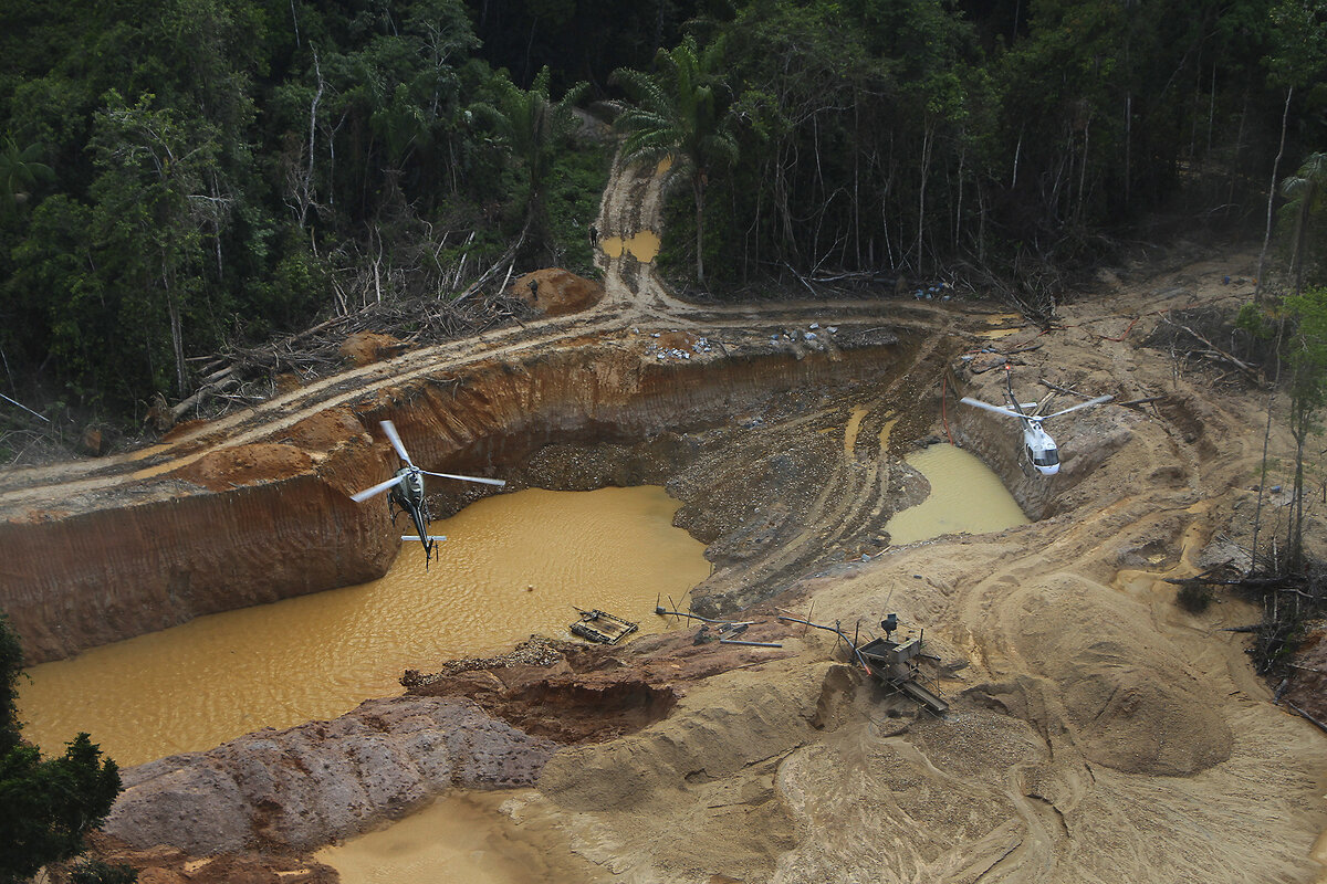 Ocher water in a pit is seen below Brazil's environmental agency helicopters, which fly over Yanomami Indigenous land in 2023.