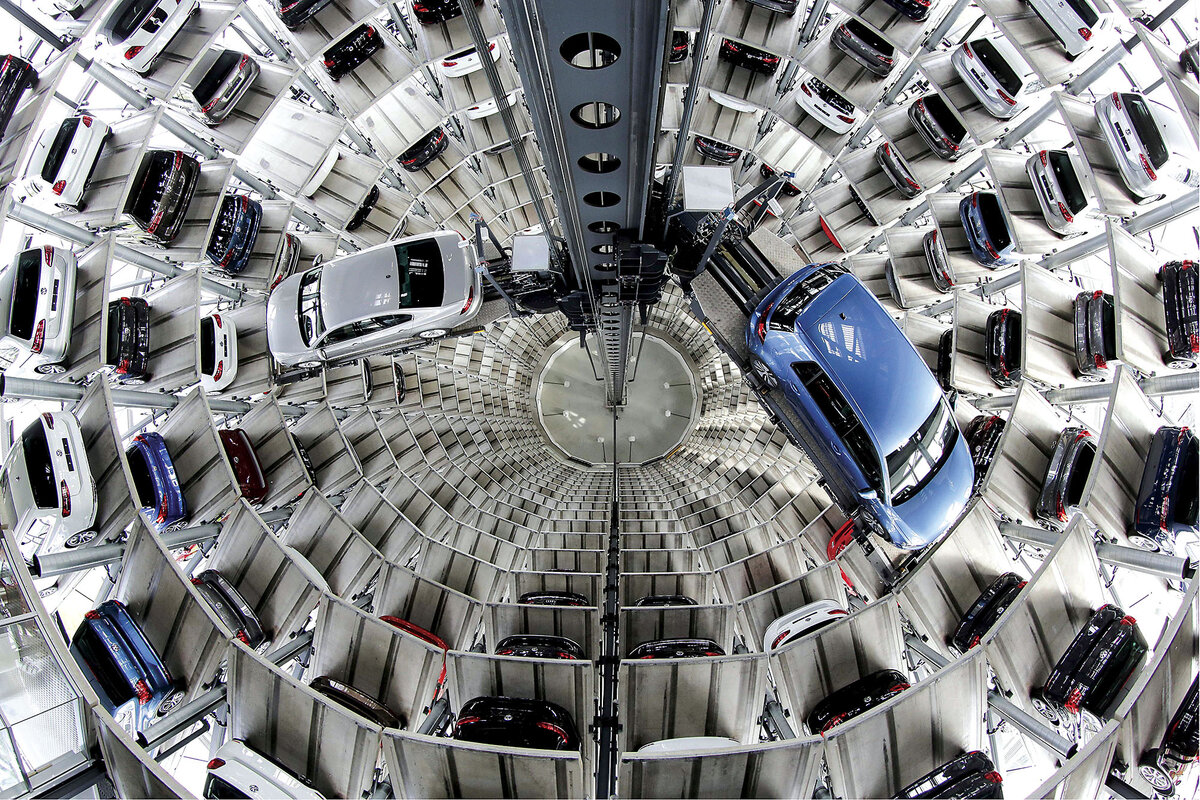 Two Volkswagen cars are displayed in a carousel tower stacked with vehicles in Wolfsburg, Germany.