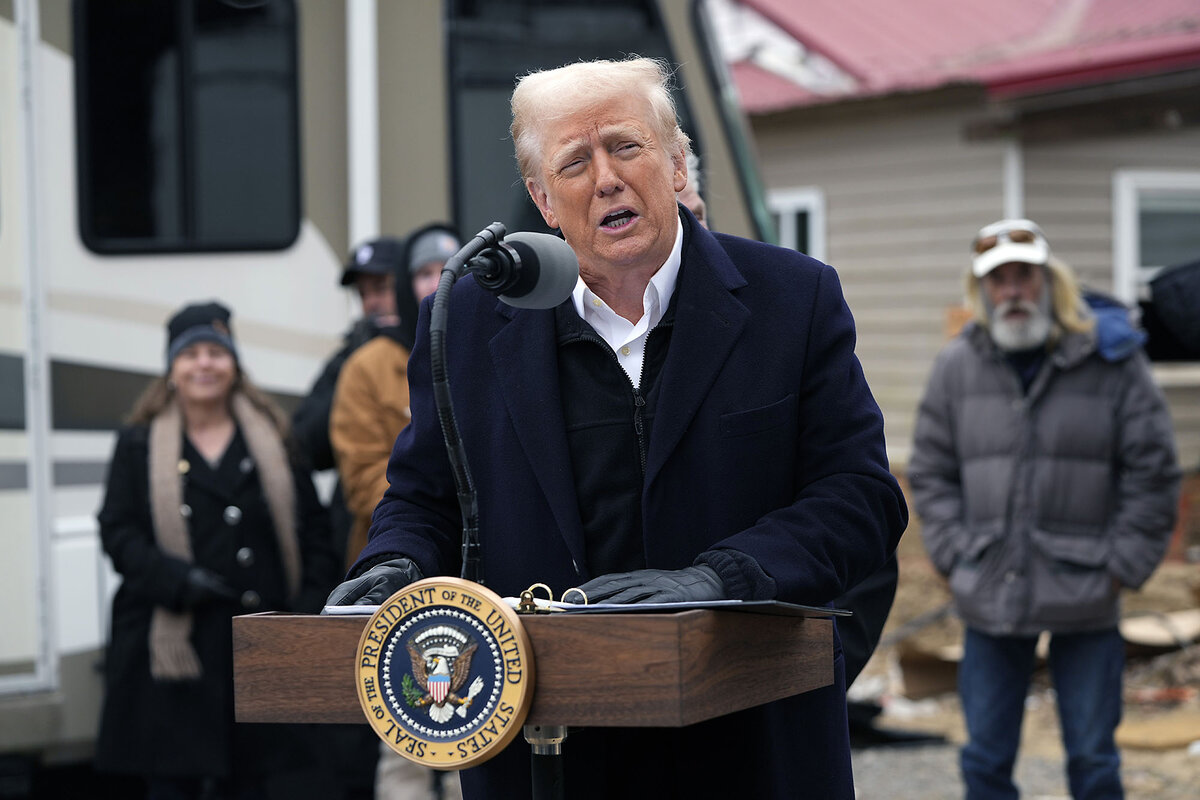 President Trump stands at a podium and speaks to people gathered after North Carolina floods