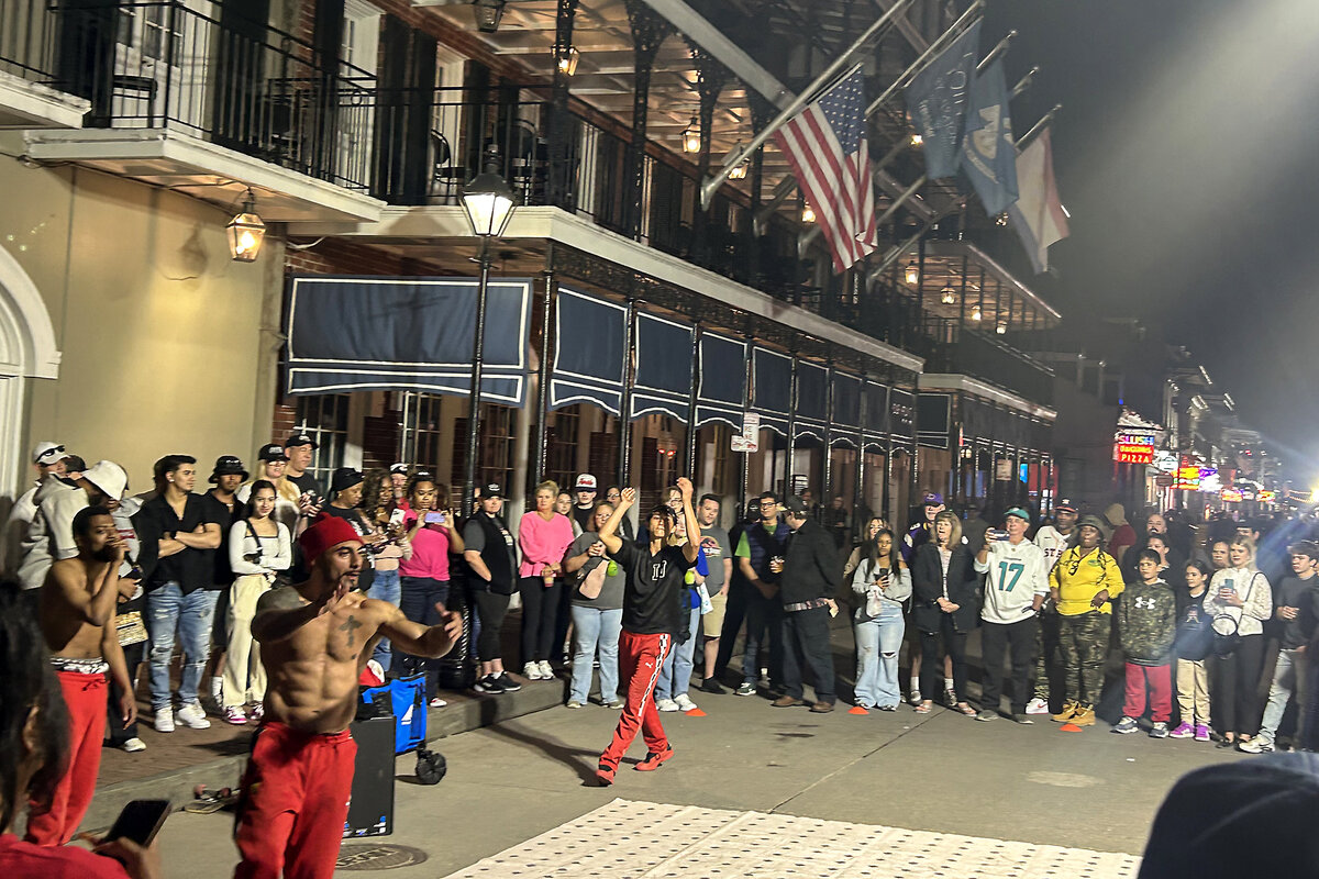 A crowd of people watches as breakers perform on Bourbon Street in New Orleans.