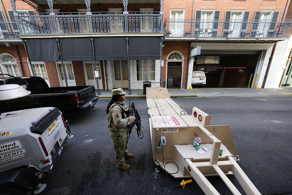 Louisiana National Guard specialist Janyria Cutno stands guard at a metal security barrier, which spans the width of the street, in the French Quarter in New Orleans, Feb. 3, 2025.