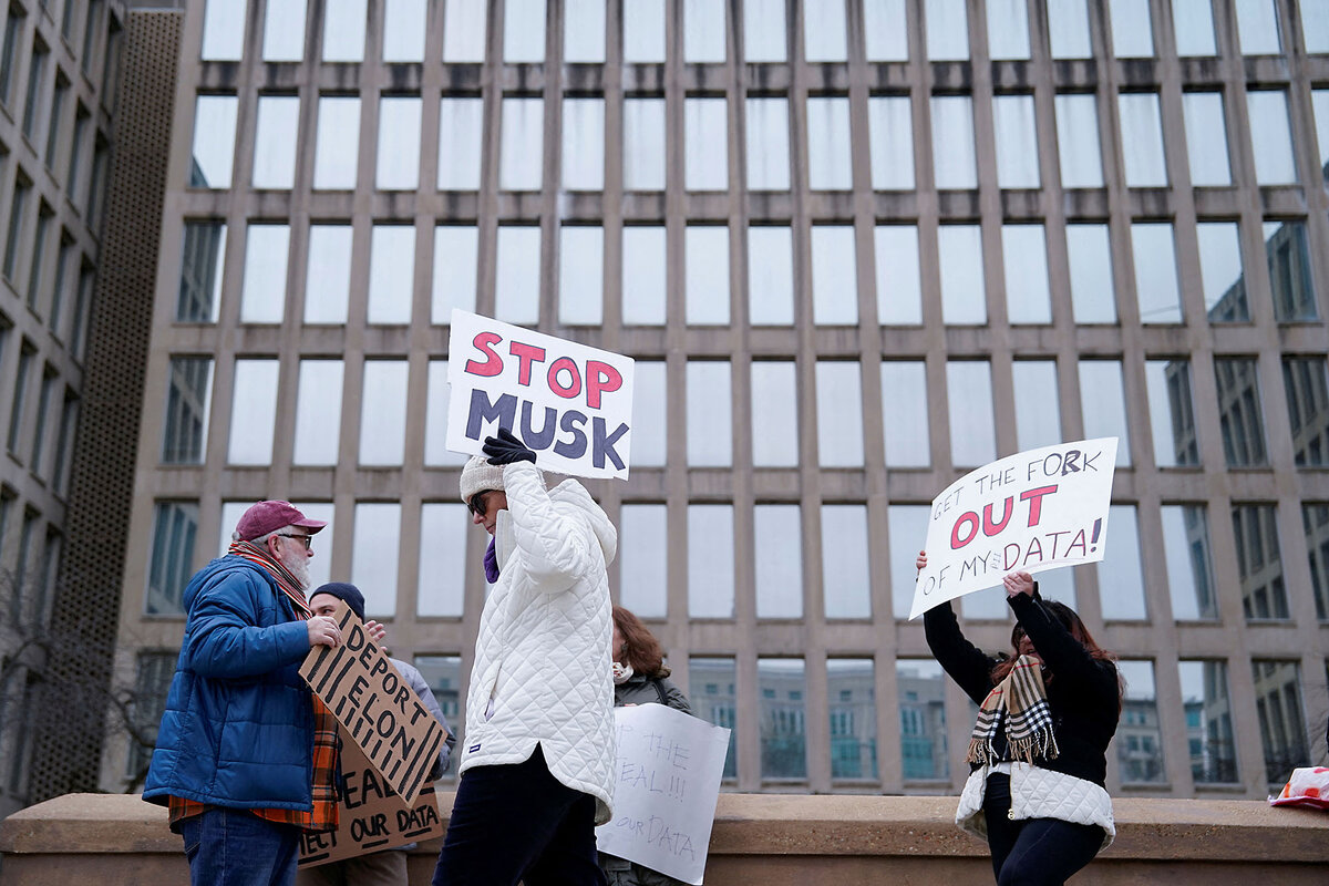 Protesters carry placards on a Washington street, including one that says "Stop Musk."