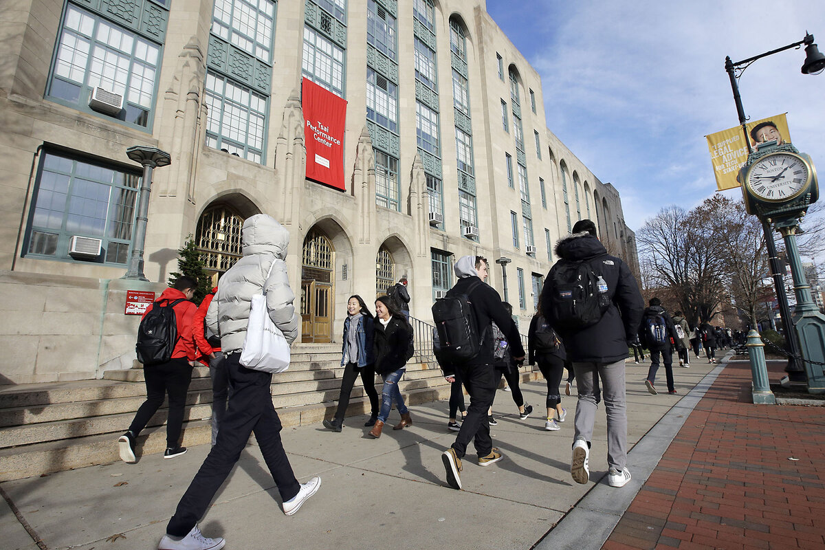 Students and pedestrians in coats walk past an entrance to Boston University's College of Arts and Sciences. 