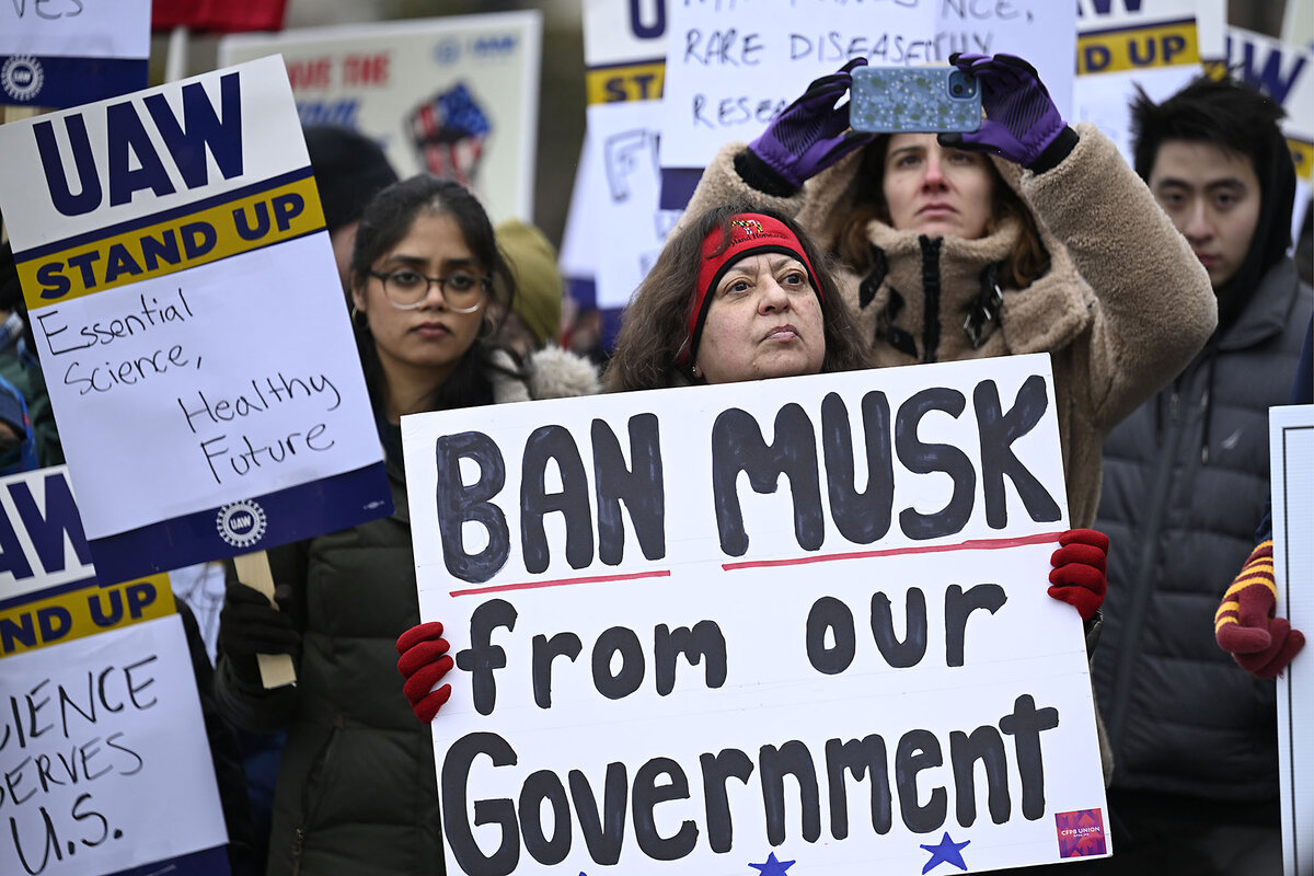 Protesters hold signs, including 'Ban Musk from our government,' and 'Essential Science, Healthy Future.'