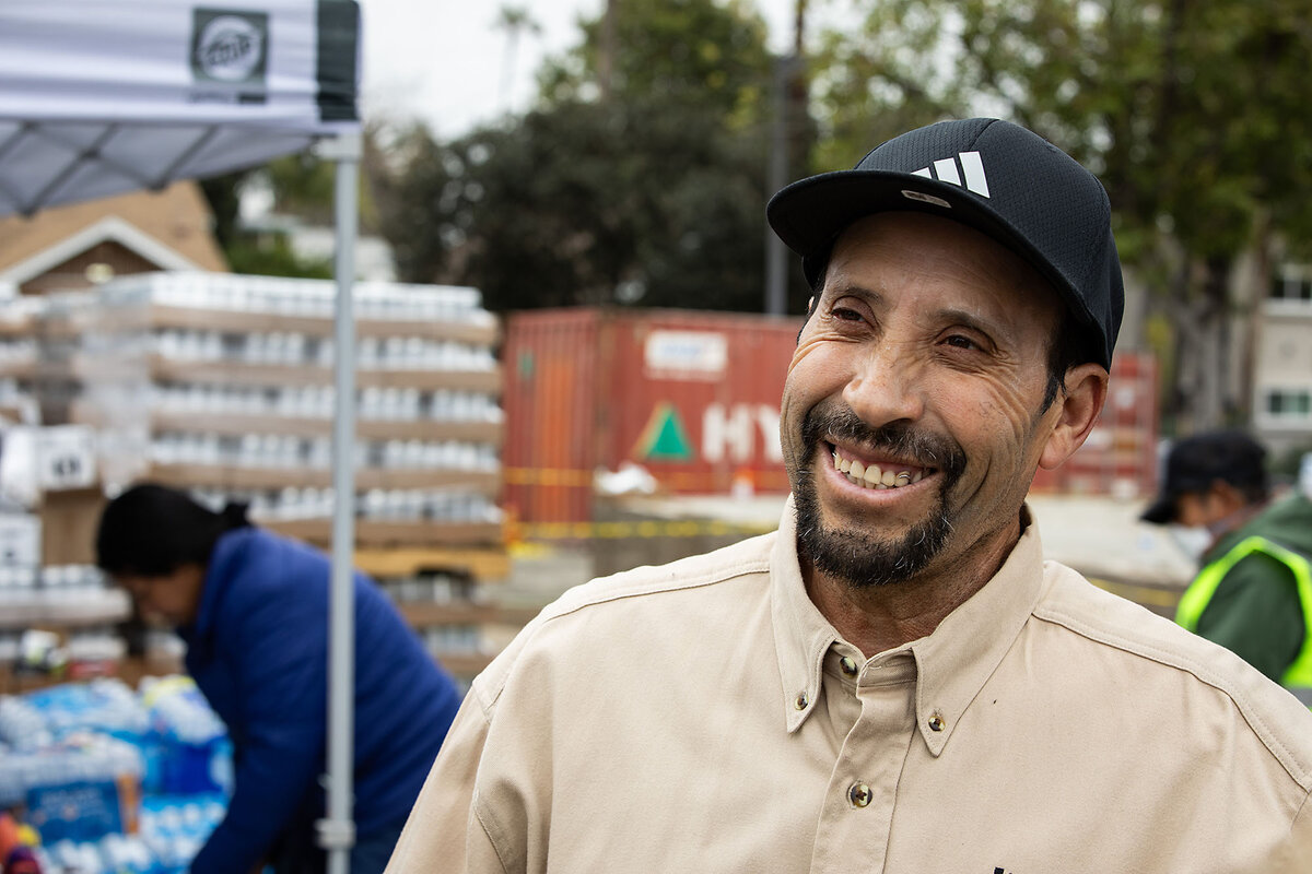 Jos茅 Tellez smiles as he volunteers at the Pasadena Community Job Center site handing out donations of food, clothing, and household goods to wildfire survivors Feb. 12, 2025, in Pasadena, California. He heard about the need for volunteers on the radio.
