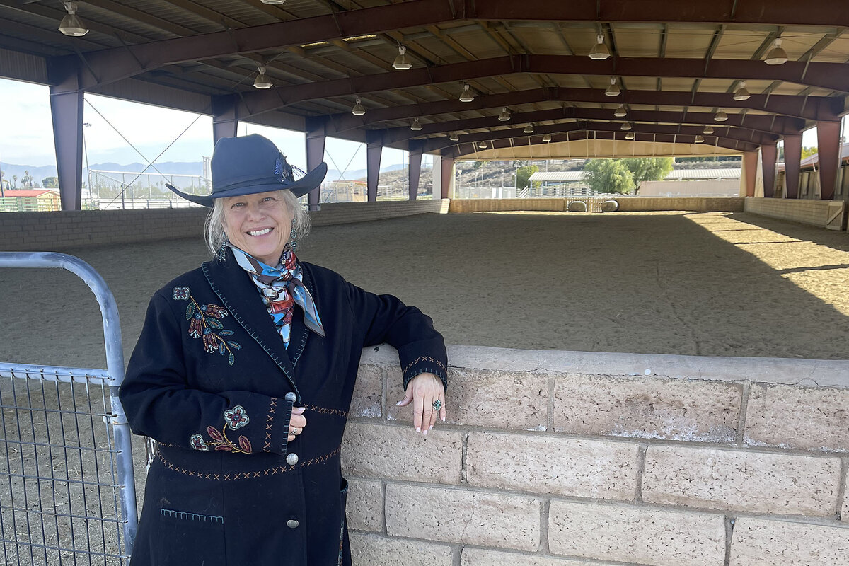 Megan Silveira visits the equine science center at Los Angeles Pierce College, Feb. 17, 2025. Ms. Silveira spent weeks at the site as a volunteer with LA County’s Equine Response Team, caring for large animals during the January wildfires. She wears a western hat and long embroidered coat so that animal owners can identify her easily during emergencies.