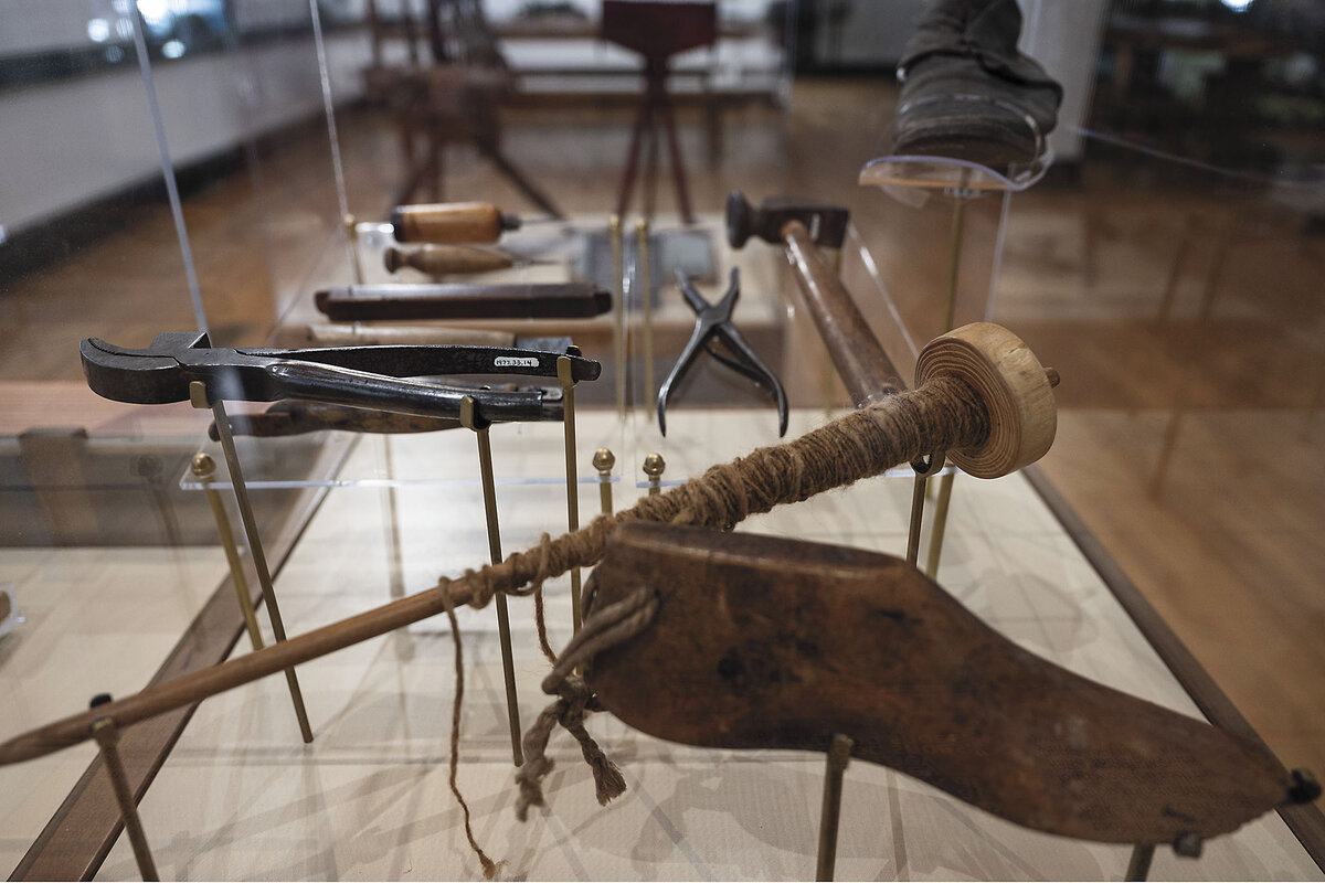 Several tools and artifacts made of wood, rope, and metal are on display.