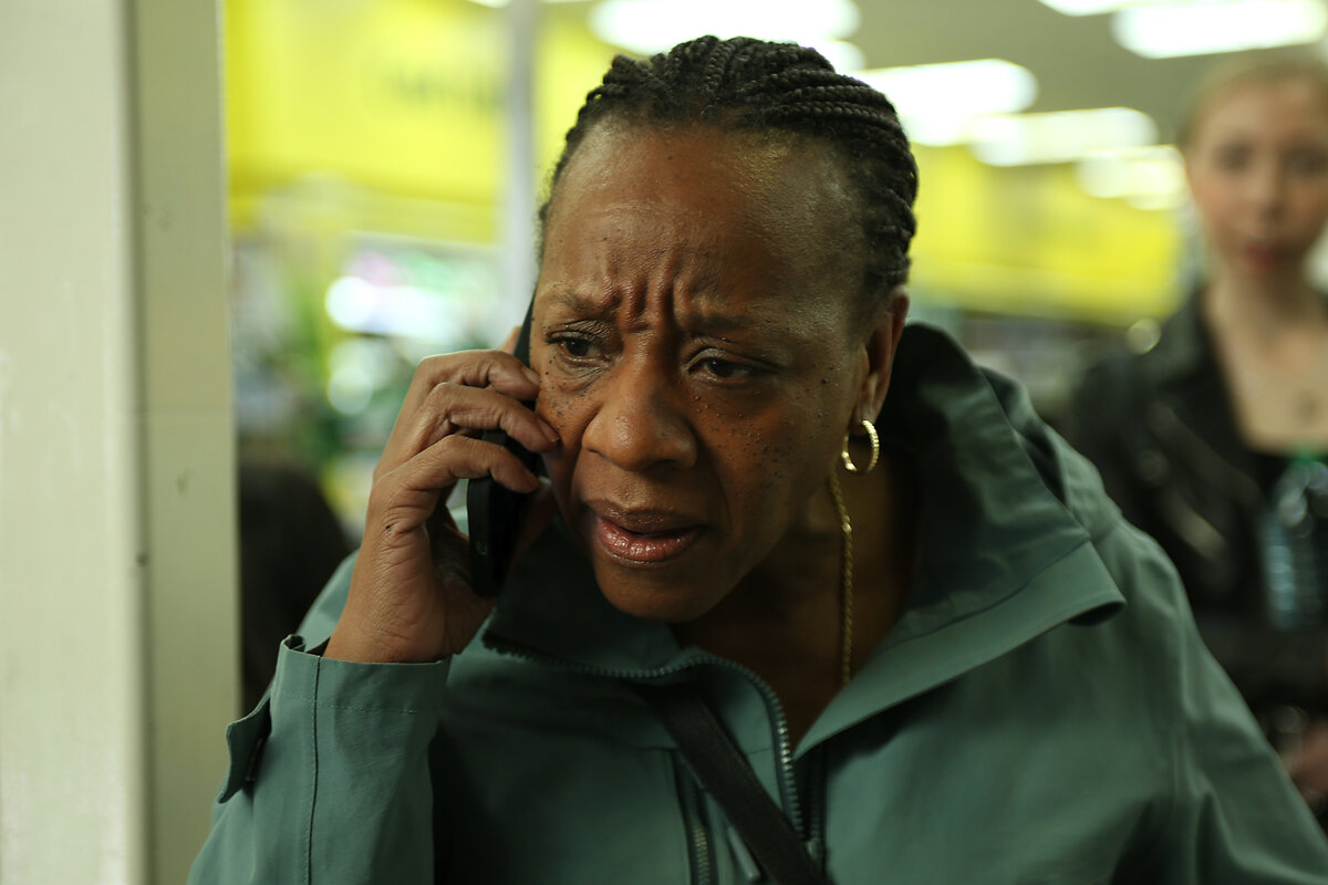 Actor Marianne Jean-Baptiste, as the character Pansy, talks on a cell phone while looking concerned. 