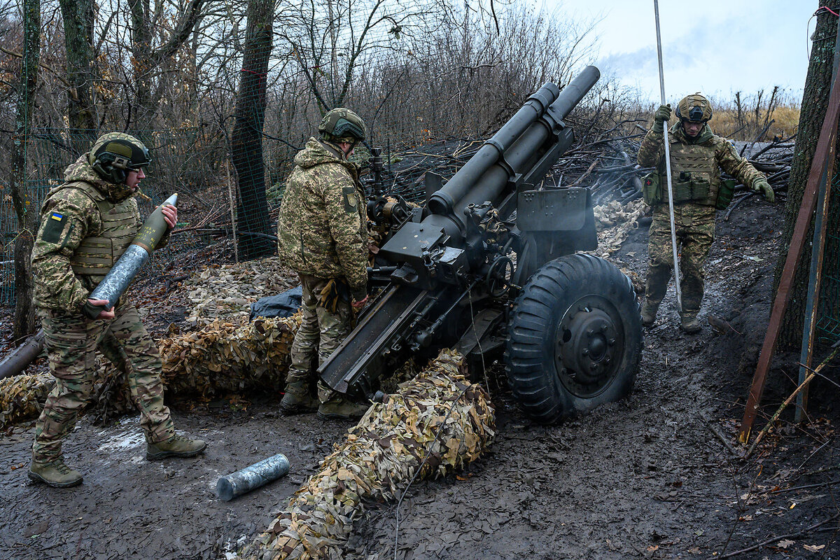 Three Ukrainian army soldiers in camouflage gear use an American artillery piece on Ukraine’s northeastern frontline with Russia, on Jan. 18, 2025, north of Kharkiv, Ukraine.