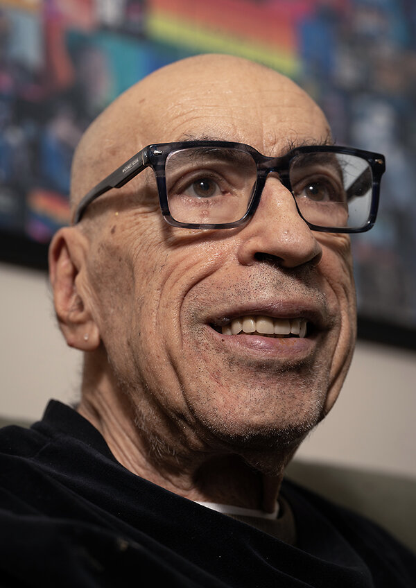 Michael Palumbaro, who survived the AIDS epidemic, smiles in his living room at the John C. Anderson Apartments in Philadelphia.