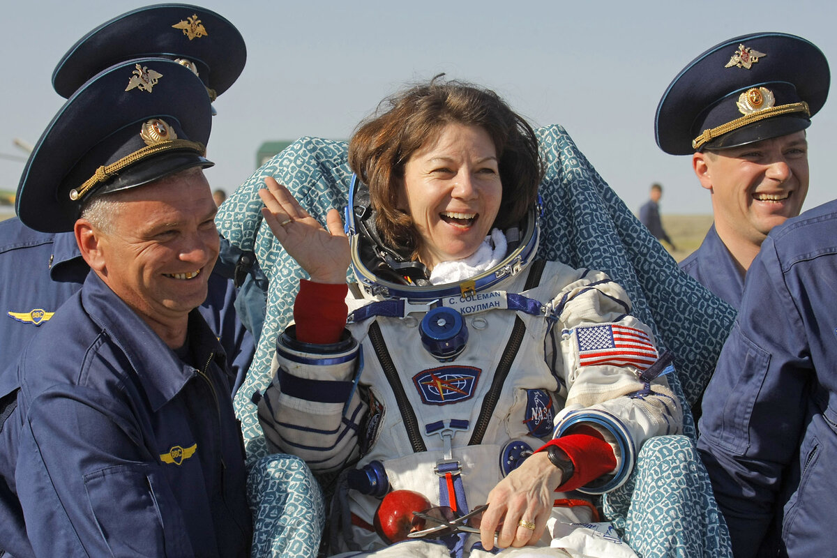 Russian space agency rescue team members carry U.S. astronaut Cady Coleman away from the landing site after the landing of the Soyuz capsule about 80 miles southeast of the Kazakh town of Dzhezkazgan, May 24, 2011.