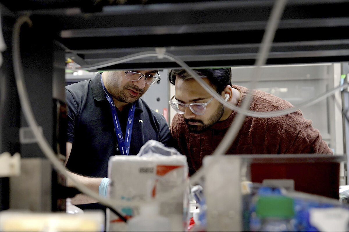 Lab workers stand together and work at Johns Hopkins University in Baltimore