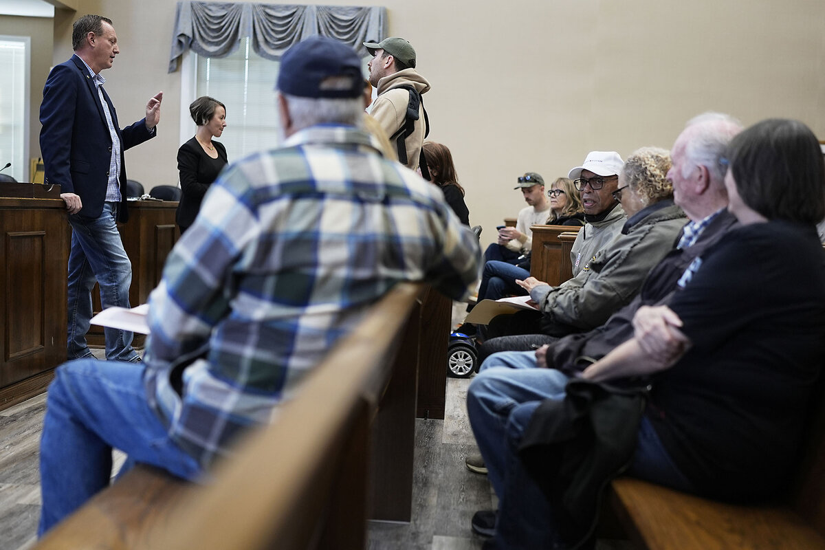 Seated constituents listen as Ray Render stands and answers their questions.