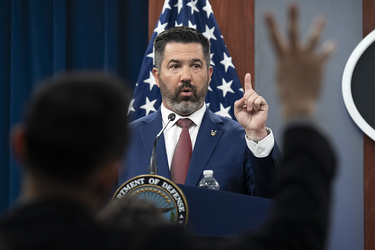 Pentagon press secretary Sean Parnell, standing in front of a flag, points to a reporter in the Pentagon press briefing room, March 17, 2025, in Washington.