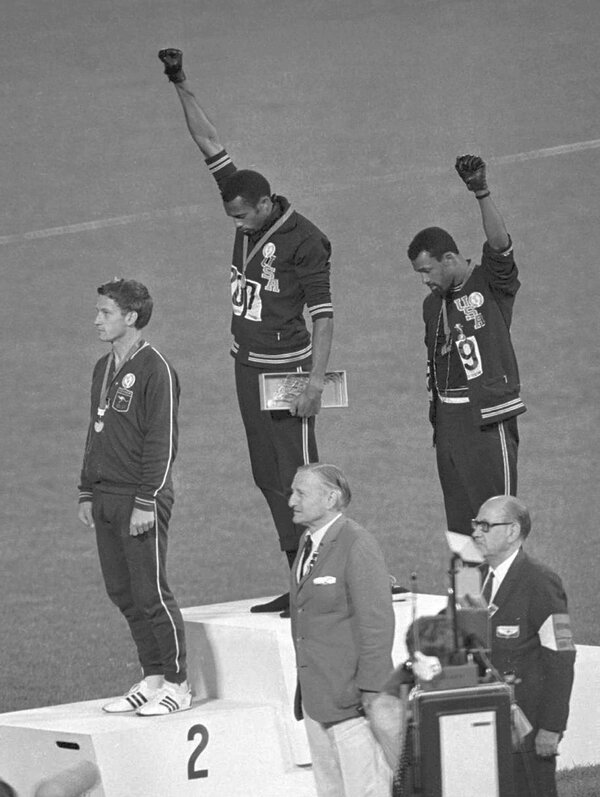 U.S. athletes Tommie Smith and John Carlos extend their gloved fists skyward on the Olympic podium