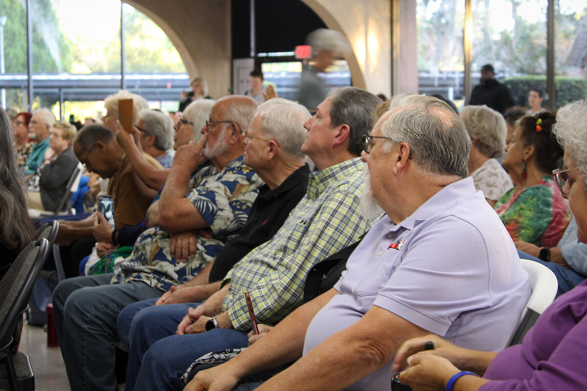 Attendees at a town hall in Silver Springs, Florida, sit in rows and listen to Democrat candidate Josh Weil speak.