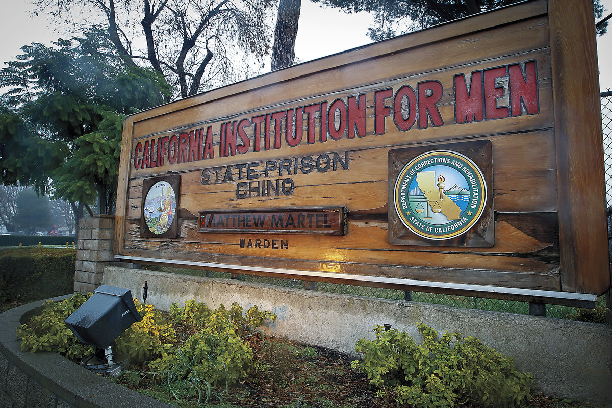A wood sign at the state prison east of LA reads 'California Institution for Men.' The Chino complex has four facilities.