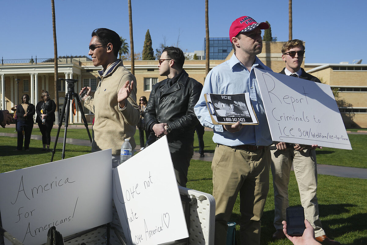 Four student members of the College Republicans United club at Arizona State University hold signs encouraging people to report criminals to ICE.