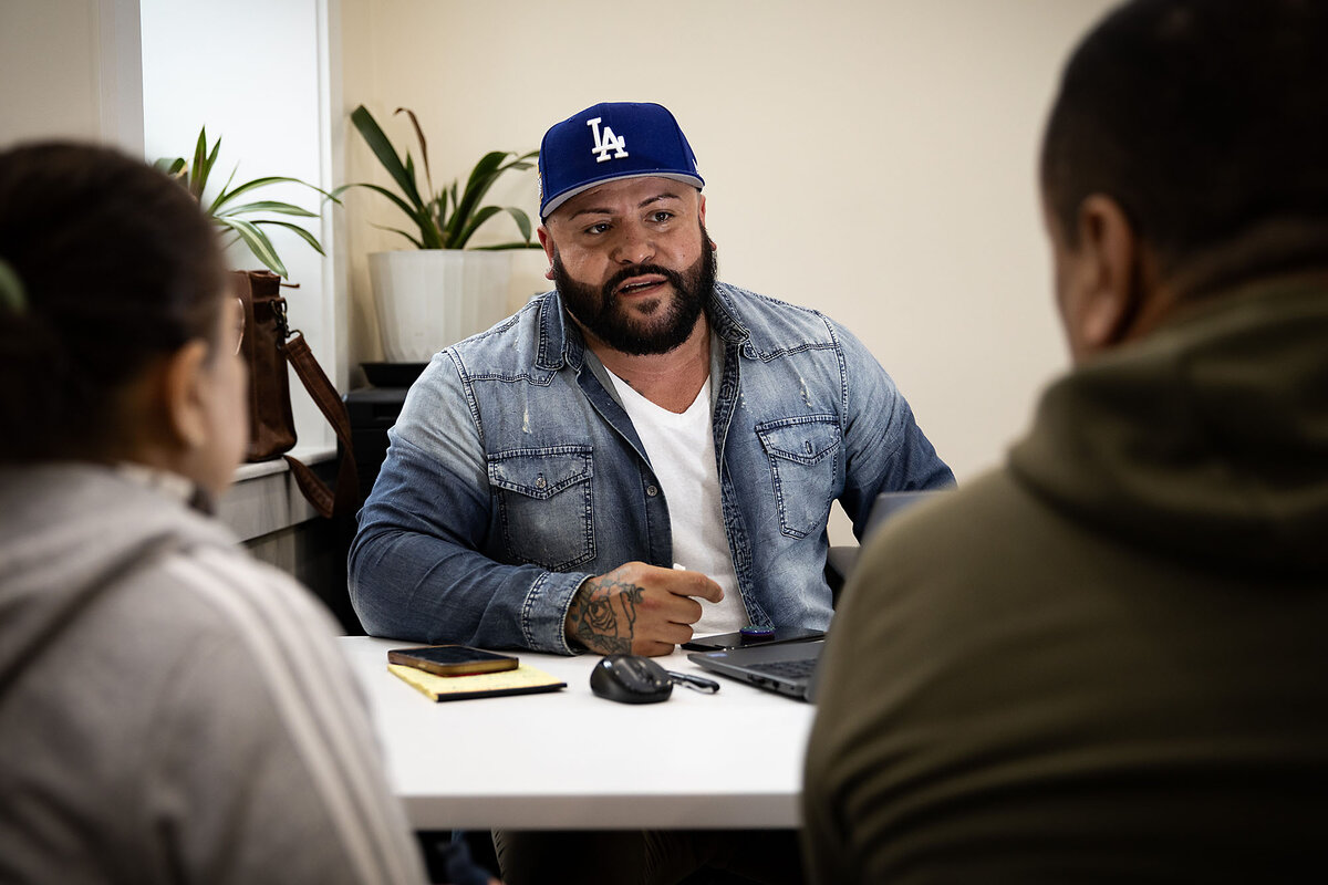 Herman Olivares, a manager at La Colaborativa, works with a couple that came in for help with a housing question, in Chelsea, Massachusetts, March 16, 2025. 