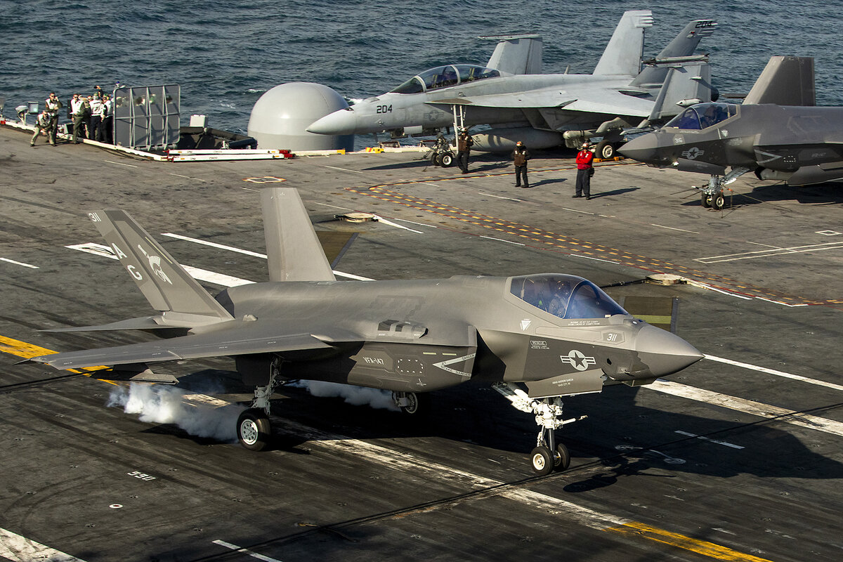 An F-35 fighter jet lands on the deck of the nuclear-powered aircraft carrier USS George Washington off the coast of Argentina, Thursday, May 30, 2024. Budget cuts could mean military branches will buy less equipment.