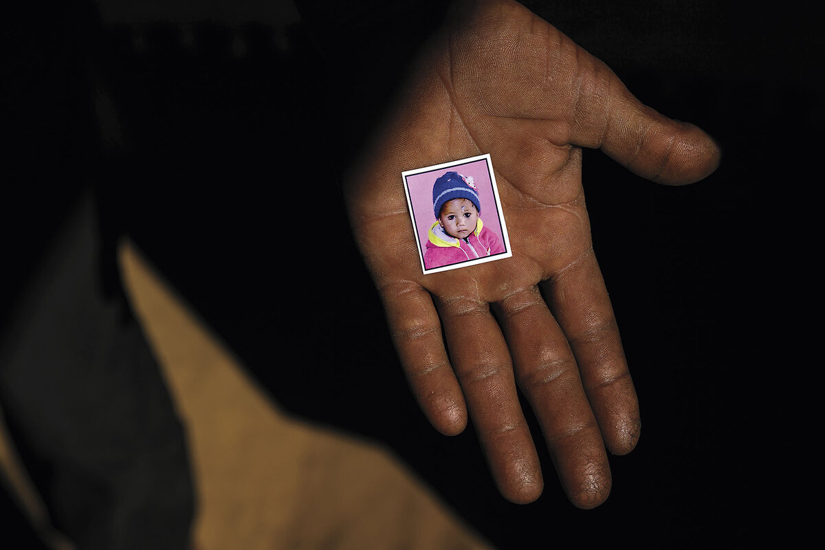 An outstretched palm displays a small photo of a young child.