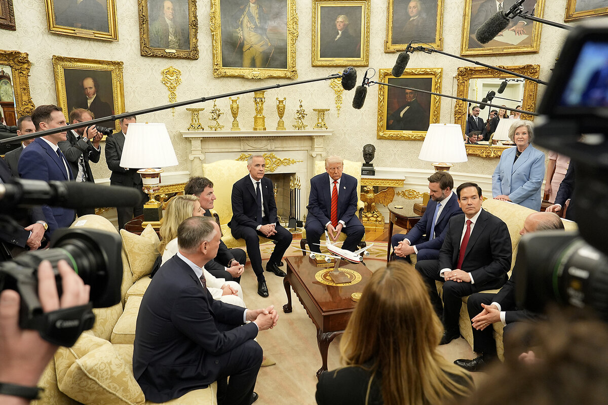Canadian Prime Minister Mark Carney and U.S. President Donald Trump sit next to each other, facing reporters, in the White House Oval Office.