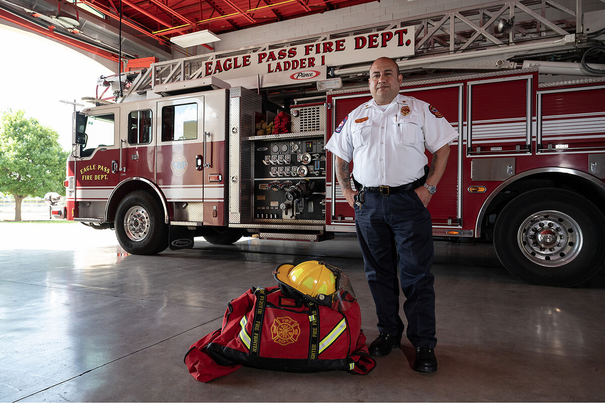 Eagle Pass Assistant Fire Chief Rodolfo Cardona stands near a ladder truck in the city’s firehouse in May. He says with fewer people trying to cross the border in his Texas town, his department is less stressed than it was last year. 