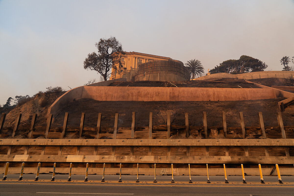 The vegetation around the Getty Villa in the Pacific Palisades neighborhood smolders on Jan. 8, 2025, the day after a wildfire swept through Los Angeles County.  