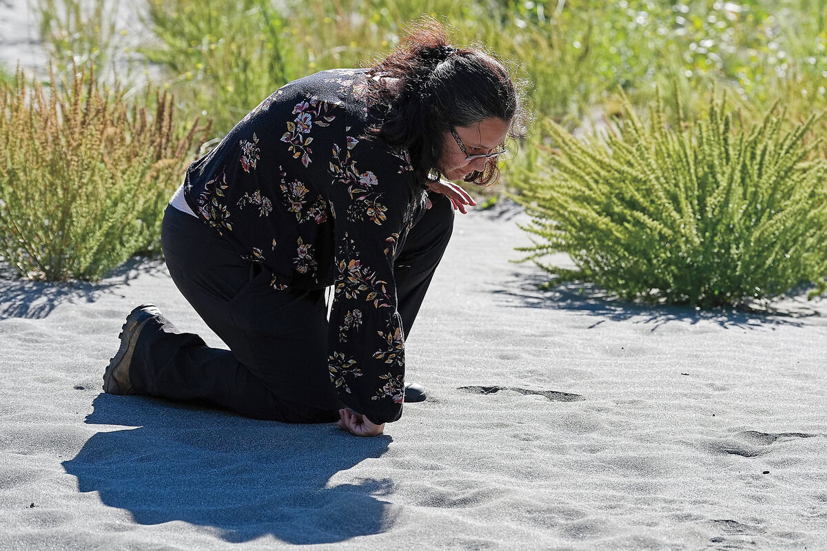 Tiana Williams-Claussen, of the Yurok Tribe Wildlife Department, examines animal prints on land being returned to the tribe.