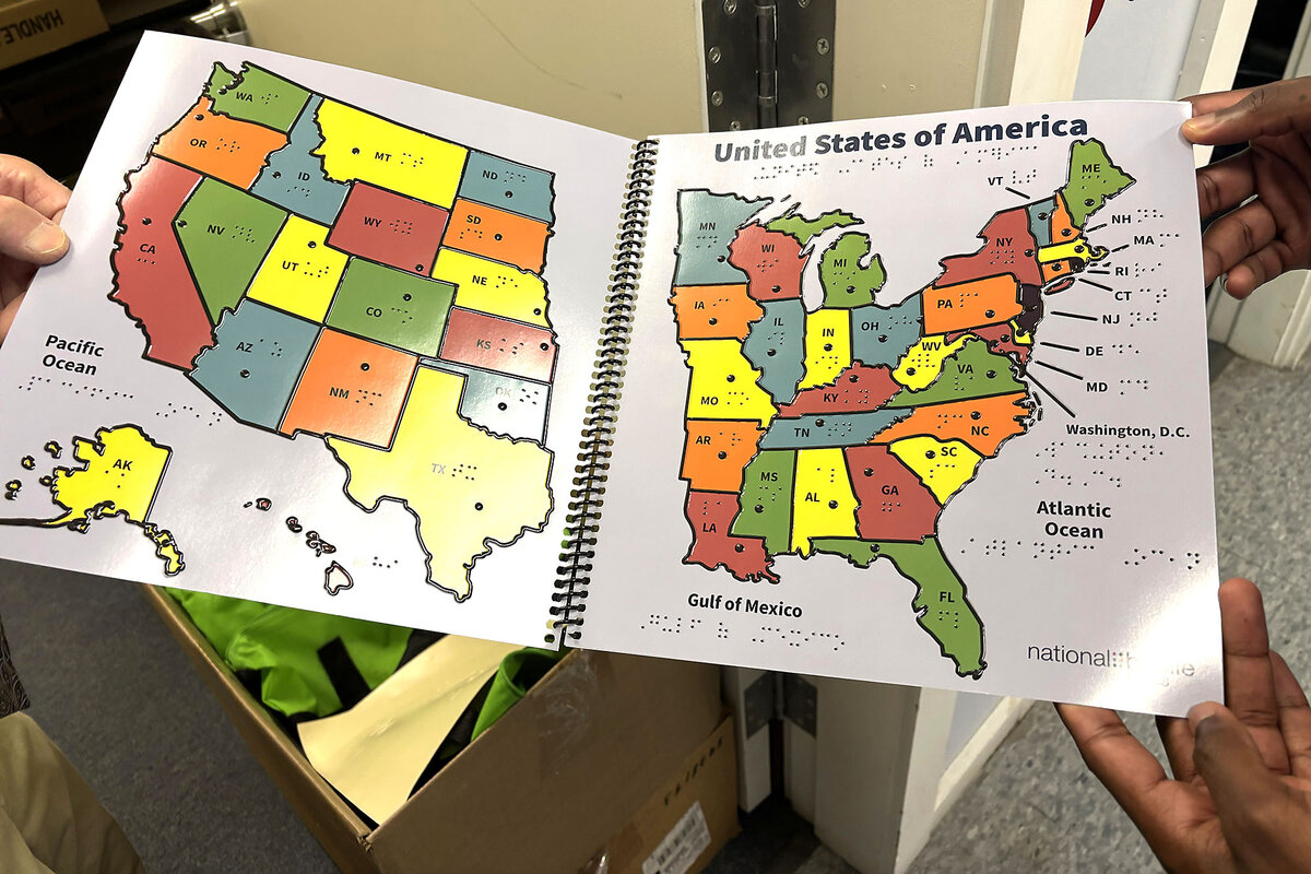 A map for children in braille is held open for a photo at the National Braille Press in Boston.