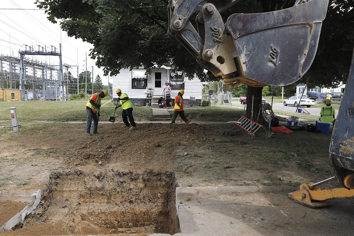 Workers backfill a hole after replacing lead pipes with copper at a home in Flint, Michigan, in 2018.