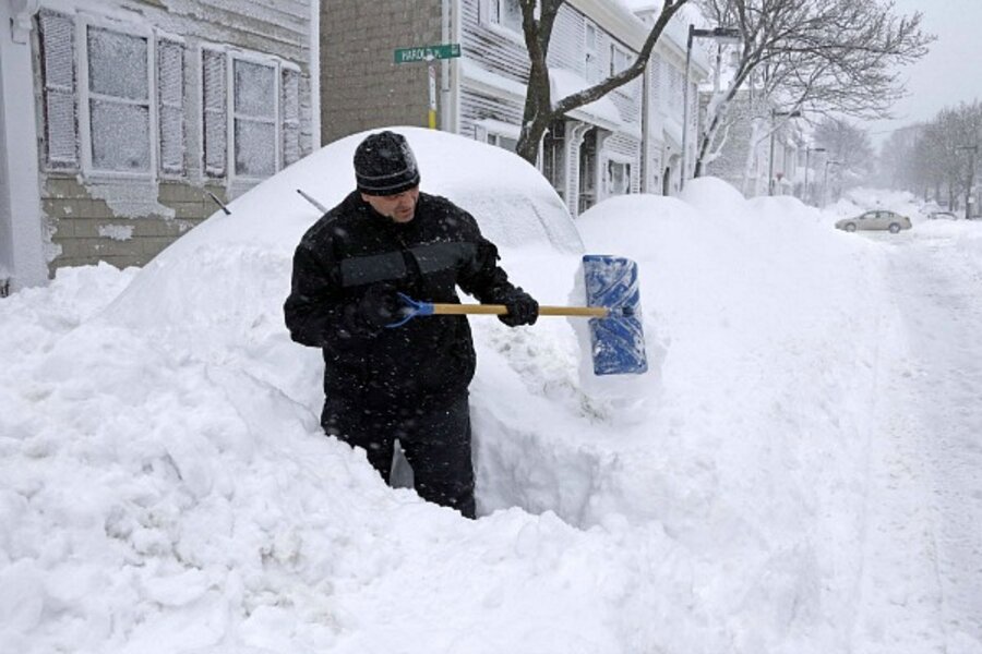 John Silver shovels between buried cars in front of his home in South Bosto...