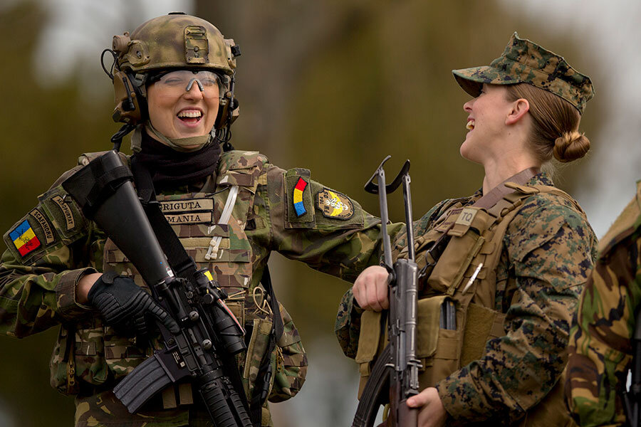 A Romanian female soldier (l.) and a female US Marine share a laugh after s...