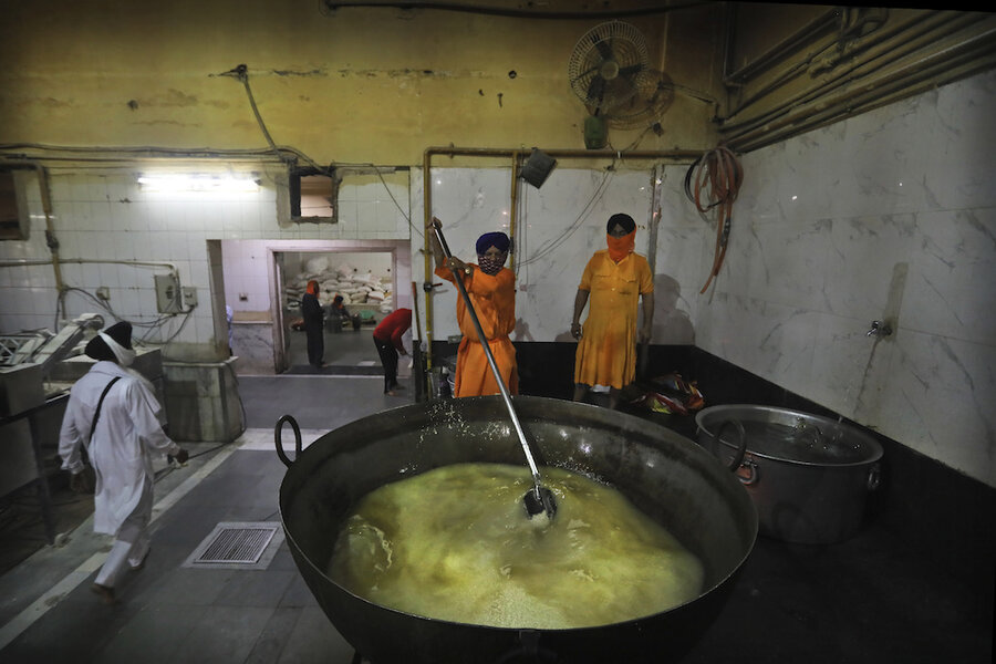 A cook in the Golden Temple cooks in an extremely large pot.