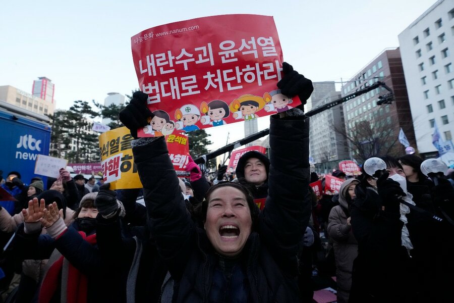 A crowd celebrates after hearing that South Korea's parliament voted to impeach President Yoon Suk Yeol, outside the National Assembly in Seoul, Dec. 14, 2024. The signs read, 