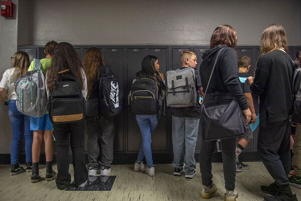 Students wearing backpacks stand in a hallway in Nowlin Middle School in Independence, Missouri.