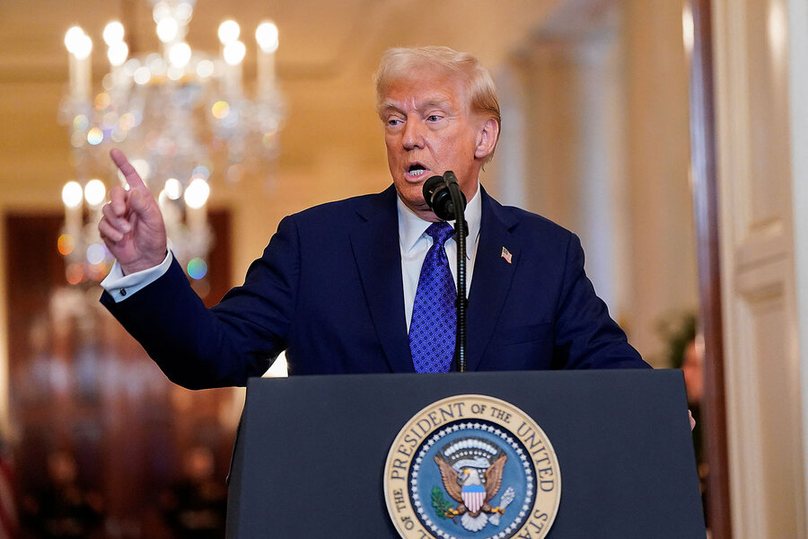 President Donald Trump gestures from a podium inside the White House.