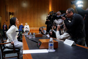 Tulsi Gabbard faces photographers as she takes her seat before the Senate Intelligence Committee.