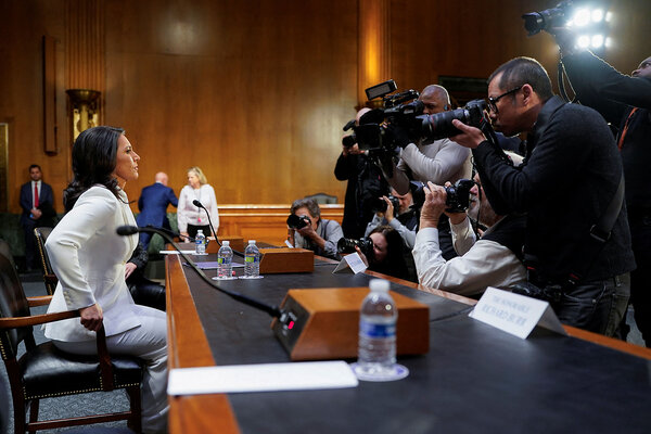 Tulsi Gabbard faces photographers as she takes her seat before the Senate Intelligence Committee.