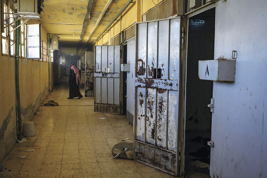 Rusted cell doors stand open along a dingy hallway in Syria's Sednaya Military Prison in Damascus.