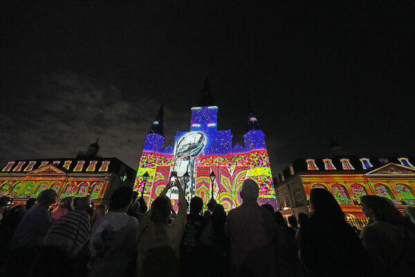 At night, a crowd in New Orleans' French Quarter watches a colorful light show projected onto St. Louis Cathedral ahead of the Feb. 9 Super Bowl.