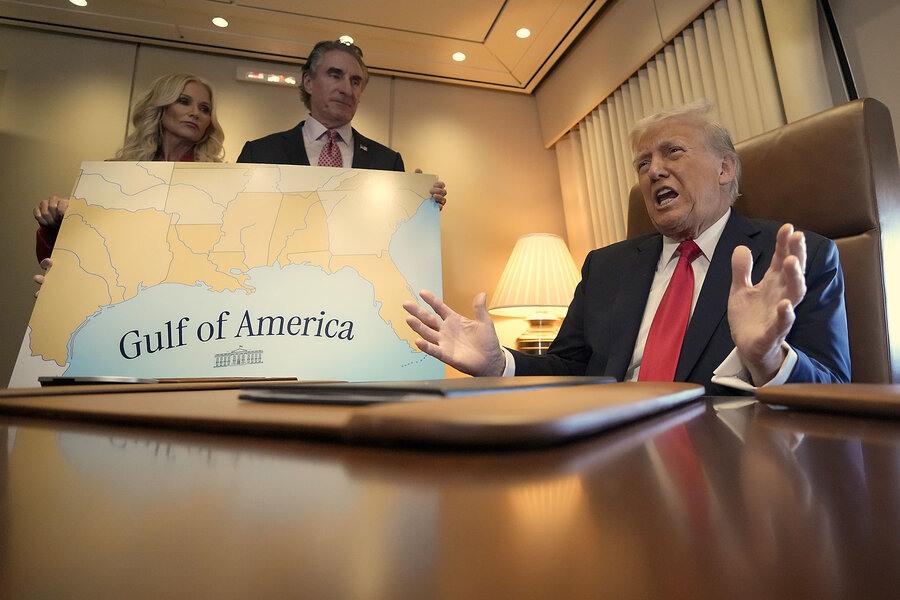 President Donald Trump, seated at a desk, speaks with a 'Gulf of America' map behind him.