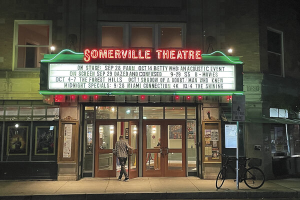 A brightly lit marquis adorns advertises film screenings above the entryway to the Somerville Theater.