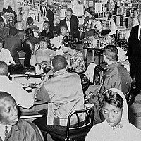 Black protesters in 1960 sit for the second day at a "white only" lunch counter at an Atlanta Woolworth Co.