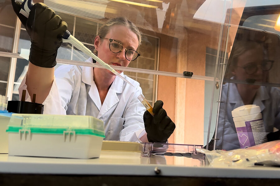 Eliah Overbey, assistant professor of bioastronautics at the University of Austin, works with tools in a lab