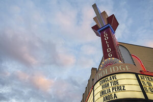 A movie theater marquis advertises showings of 'Conclave,' 'High Tide,' 'Emilia Perez,' and 'Anora.'