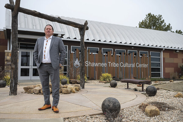 Chief Ben Barnes, dressed in a suit, stands in front of the Shawnee Tribe Cultural Center.