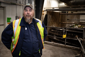 A man in high-visibility vest stands in front of a turbo separator, which extracts organic waste from packaging.