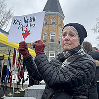 A woman holds a sign in support of Canadians visiting the Haskell Free Library & Opera House, which sits on the U.S.-Canada border. 